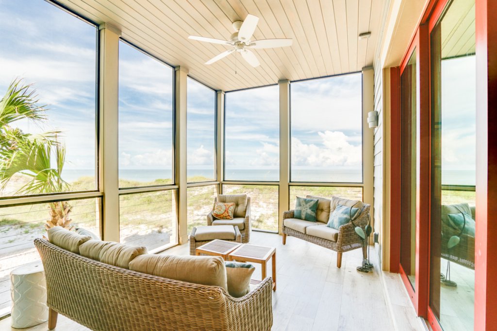 covered screened in patio area with view of ocean in cape san blas, couches and tables facing each other