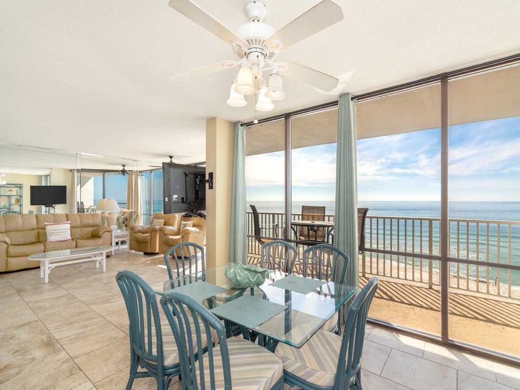 inside living room with glass table and chairs and sofa staring out into oceanfront views