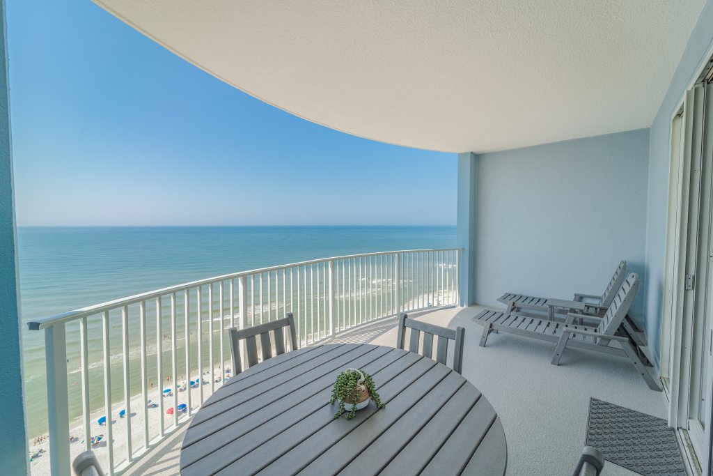 outdoor balcony furniture looking out into the ocean with white railing