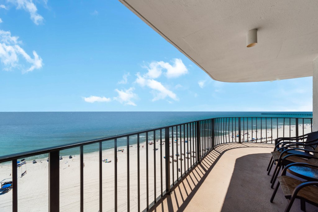 Balcony view of white sand beach on a sunny day with clear blue skies in Panama City Beach