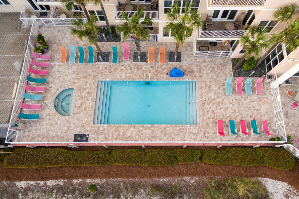 a birds-eye view of a pool, colorful lounge chairs, resorts in destin, condo