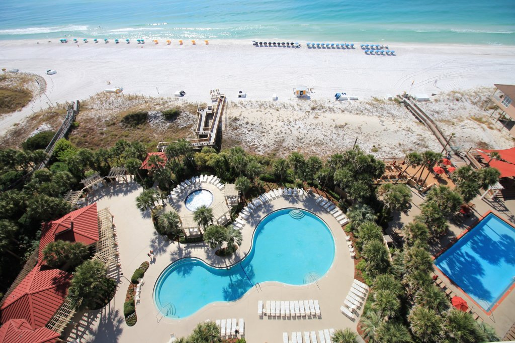 view of the beach from a condo, pool, white lounge chairs, resorts in destin