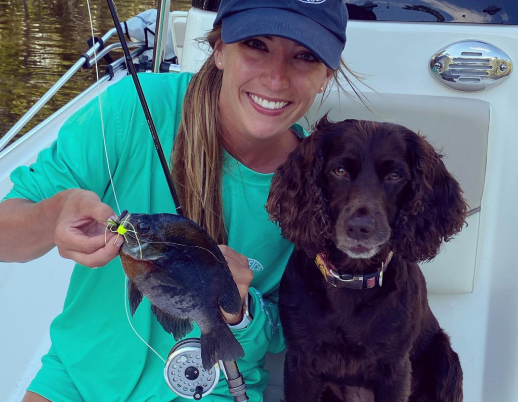 girl next to her dog on boat at lake wimico