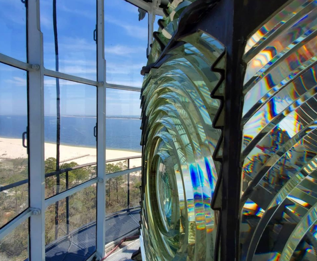 looking out the window to the beach from the top of a lighthouse