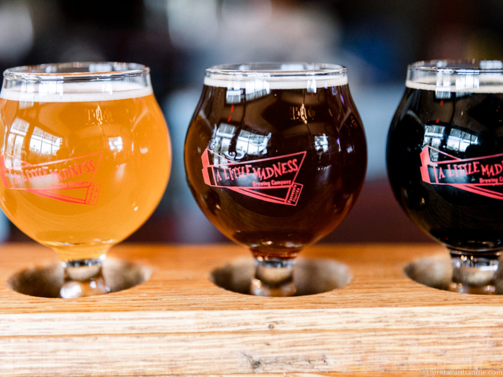 an orange beer, brown beer, and black colored beer side by side.