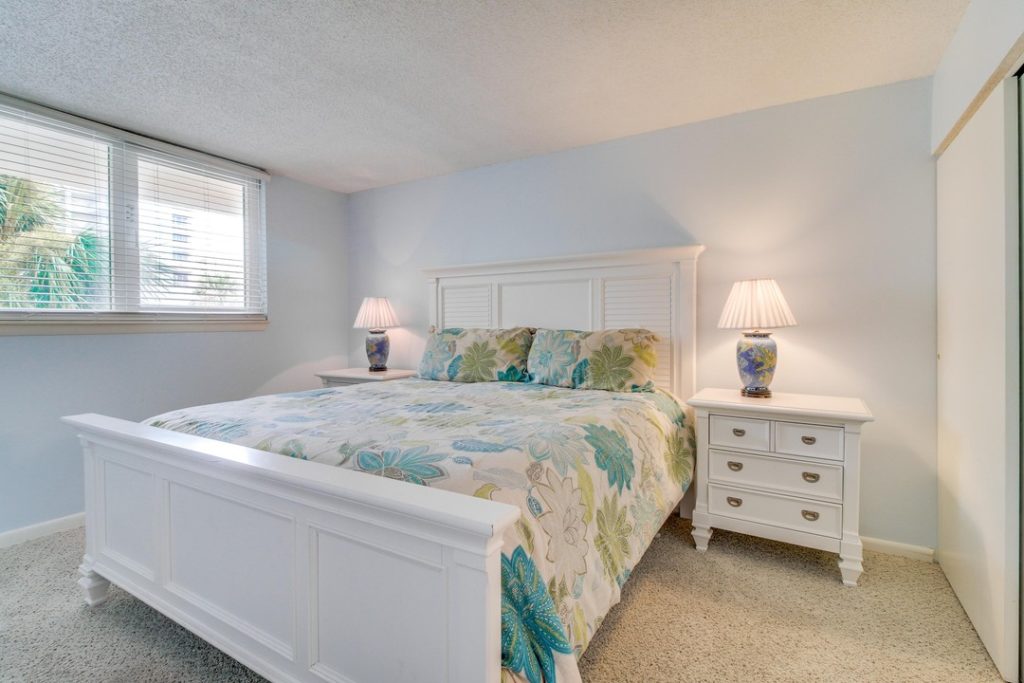 queen bed with floral bedding, cheap vacation rental in pensacola beach