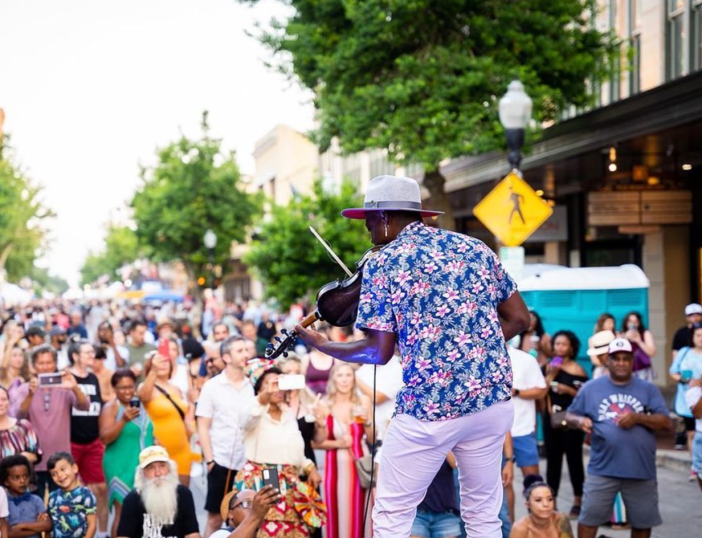 man preforming infront of a crowd in downtown pensacola florida, gallery night