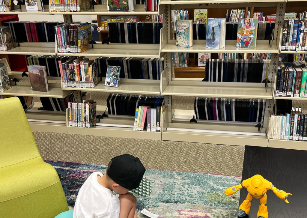 kid sitting down on rug inside a destin library